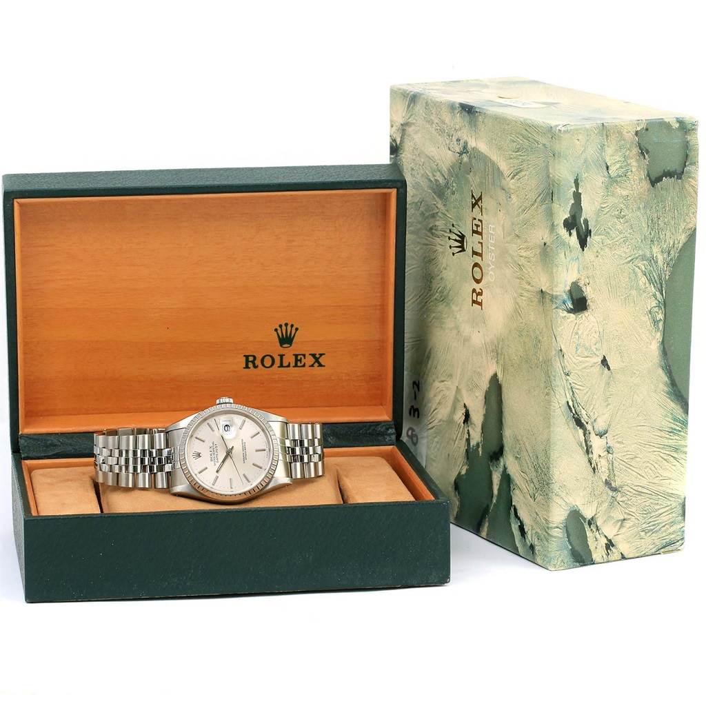 The Rolex Datejust 16220 Men
s Stainless Steel Silver Dial 16220 Men
s Stainless Steel Silver Dial watch is displayed in an open wooden box, accompanied by its outer marble-patterned packaging.