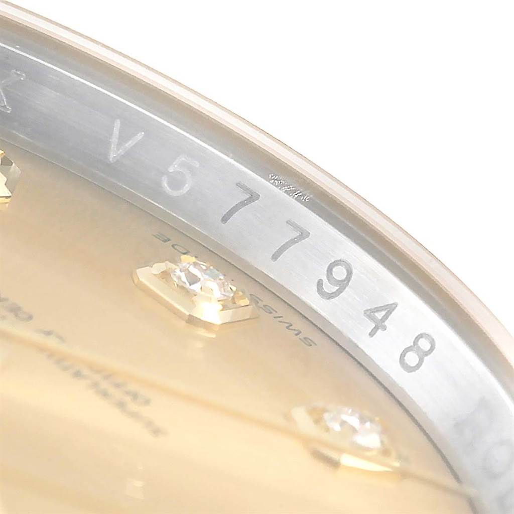 The image shows a close-up of the serial number engraved on the rehaut of a Rolex Datejust 116233 Men
s Stainless Steel Champagne Dial 116233 Men
s Stainless Steel Champagne Dial watch, revealing part of the dial and diamond markers.