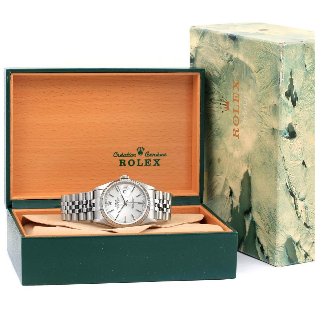 The Rolex Datejust 16234 Men
s Stainless Steel Silver Dial 16234 Men
s Stainless Steel Silver Dial watch is shown in its open box alongside the outer packaging from a front angle.