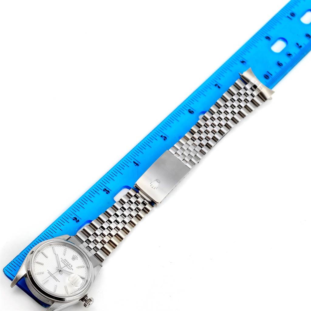 The Rolex Datejust 16200 Men's Stainless Steel Silver Dial 16200 Men's Stainless Steel Silver Dial watch is shown from a top-down angle, displaying the dial, bracelet, and clasp against a ruler.