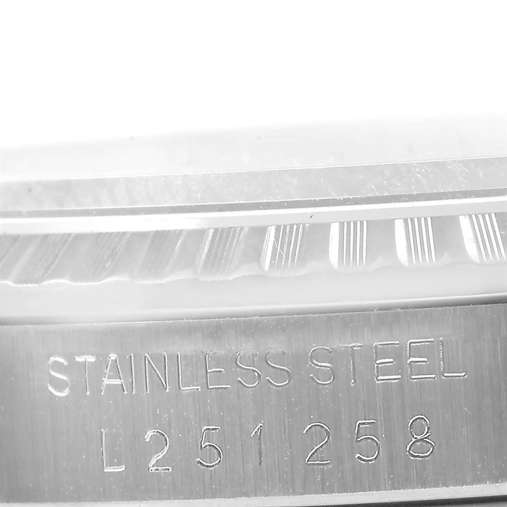 This close-up image shows the engraved serial number and "STAINLESS STEEL" marking on the side of a Rolex Datejust 16220 Men
s Stainless Steel Silver Dial 16220 Men
s Stainless Steel Silver Dial watch.