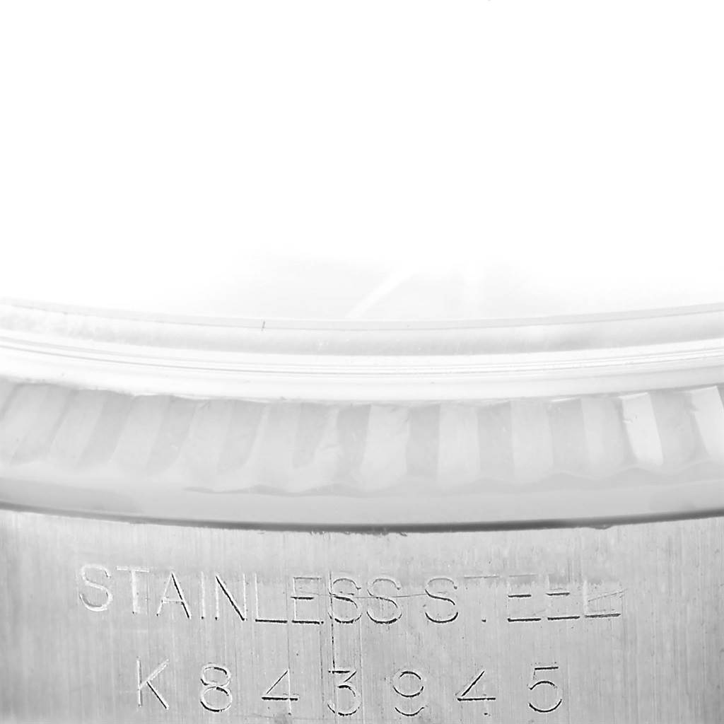 A close-up of the serial number and fluted bezel of a Rolex Datejust 16234 Men's Stainless Steel Blue Dial 16234 Men's Stainless Steel Blue Dial watch in stainless steel.