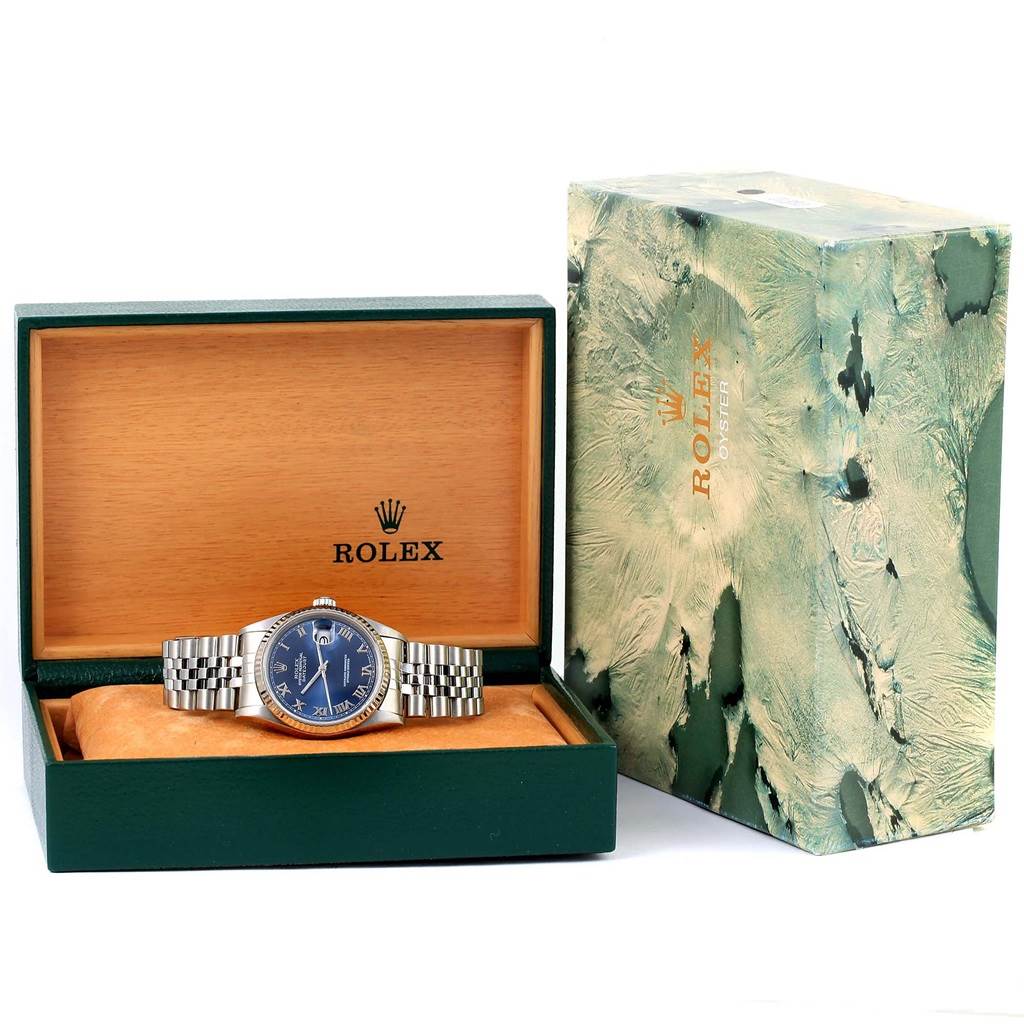 The image shows a Rolex Datejust 16234 Men's Stainless Steel Blue Dial 16234 Men's Stainless Steel Blue Dial watch with a blue dial and silver bracelet, inside an open Rolex box, with the outer box placed beside it.
