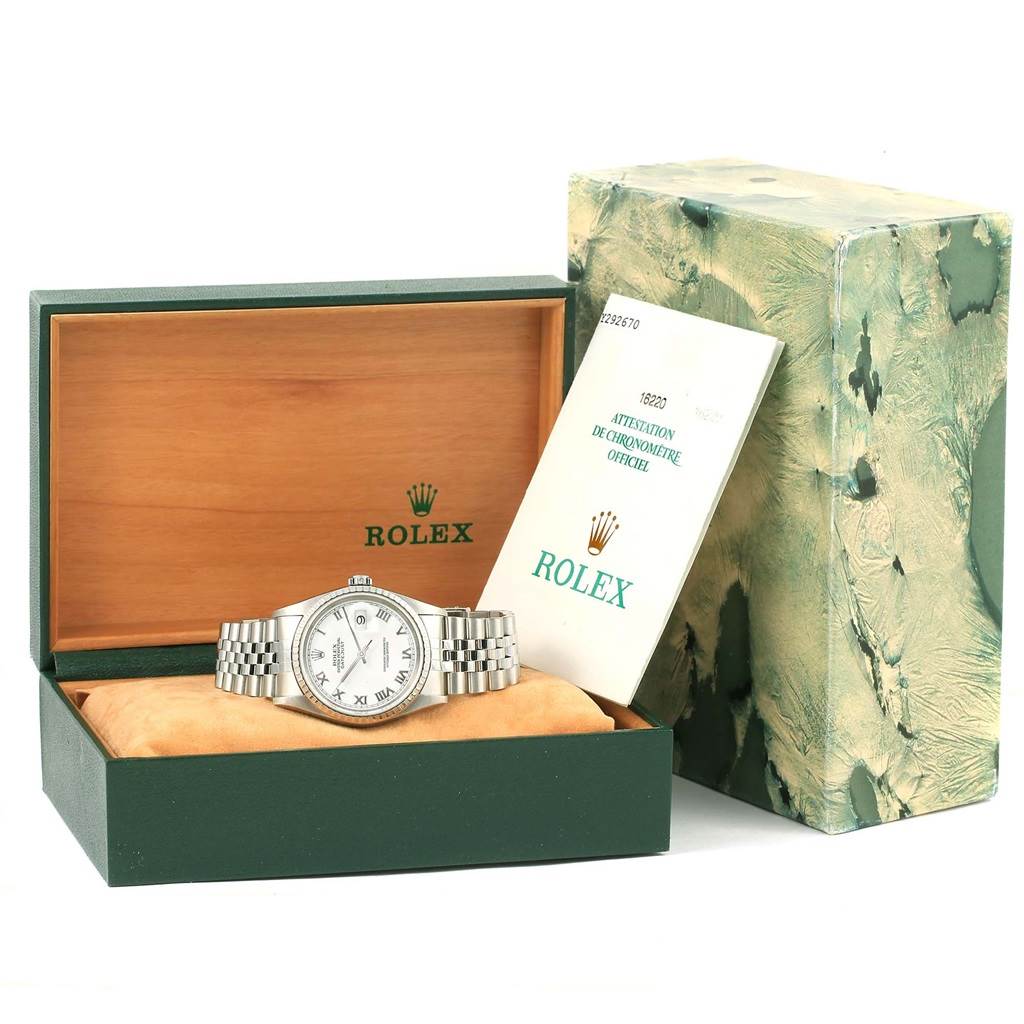 The Rolex Datejust 16220 Men
s Stainless Steel White Dial 16220 Men
s Stainless Steel White Dial watch is displayed in its open box with accompanying paperwork beside it.