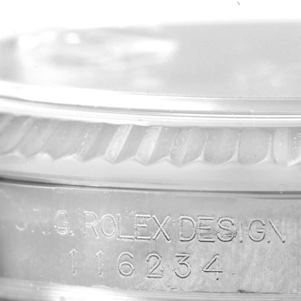 This image shows the side view of a Rolex Datejust 116234 Men's Stainless Steel Blue Dial 116234 Men's Stainless Steel Blue Dial watch focusing on the engraved serial number and fluted bezel.