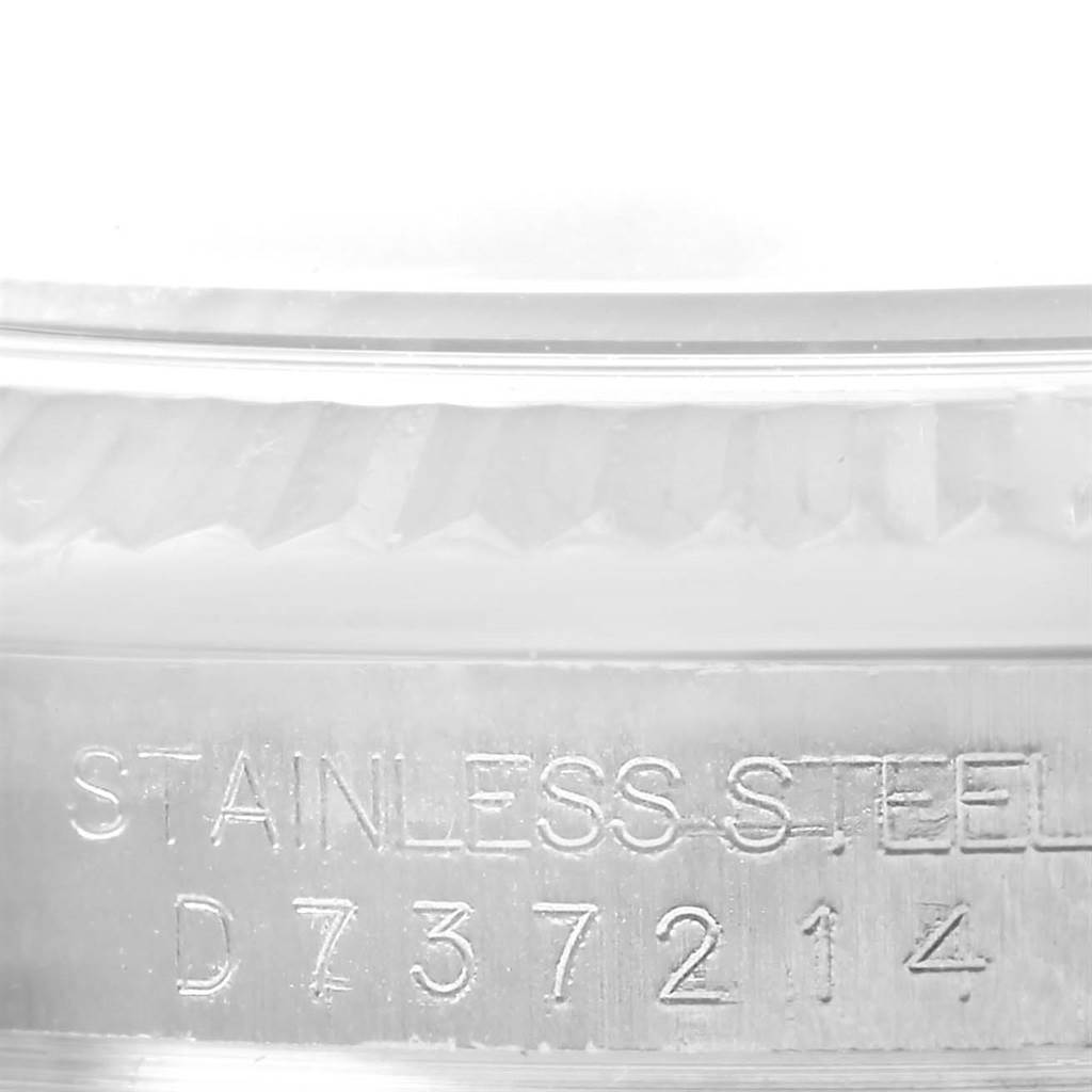 This photo shows the side engraving and part of the fluted bezel of a Rolex Datejust 116234 Men's Stainless Steel Blue Dial 116234 Men's Stainless Steel Blue Dial watch.