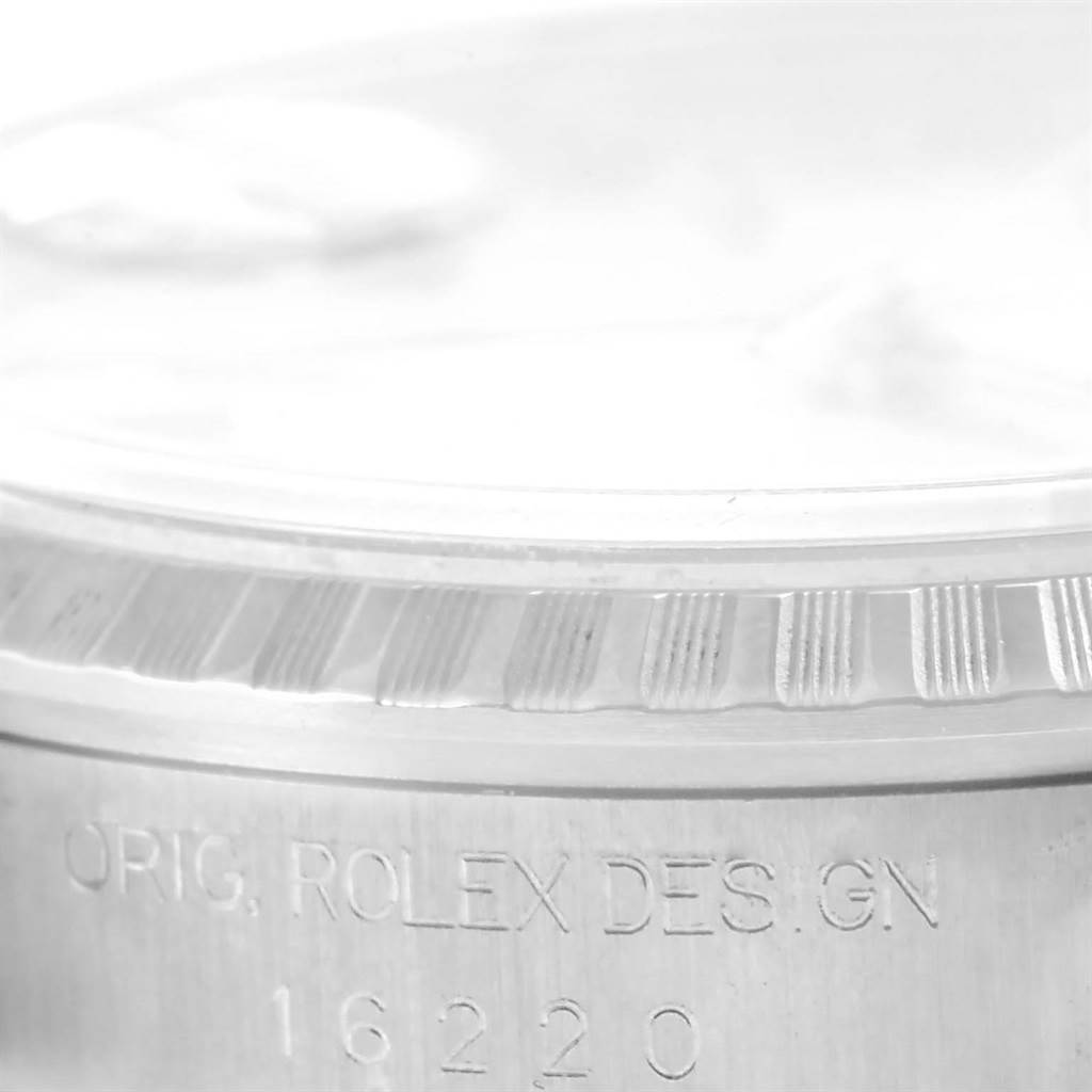 The image shows a close-up of the Rolex Datejust 16220 Men
s Stainless Steel Silver Dial 16220 Men
s Stainless Steel Silver Dial model 16220, focusing on the bezel and engraved model number.
