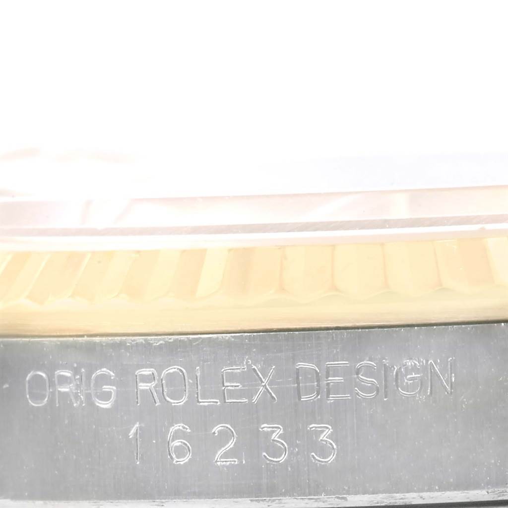This is an angled close-up showing the engraved case back and fluted bezel of a Rolex Datejust 16233 Men's Steel and Gold (two tone) Champagne Dial 16233 Men's Steel and Gold (two tone) Champagne Dial model.