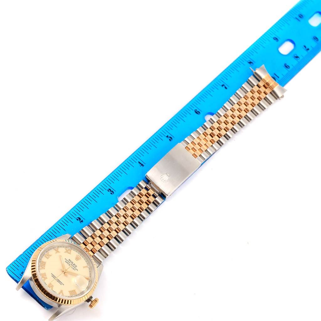 The Rolex Datejust 16233 Men's Steel and Gold (two tone) Beige Dial 16233 Men's Steel and Gold (two tone) Beige Dial watch is shown in a top-down angle with its face, jubilee bracelet, and clasp visible alongside a ruler for measurement.