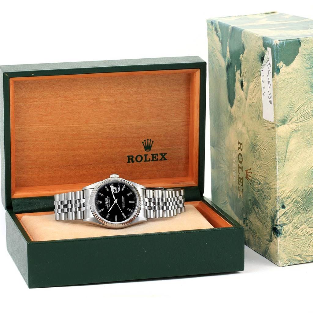 The Rolex Datejust 16234 Men
s Stainless Steel Silver Dial 16234 Men
s Stainless Steel Silver Dial watch is displayed front-on in its open box, with the outer packaging positioned next to it.