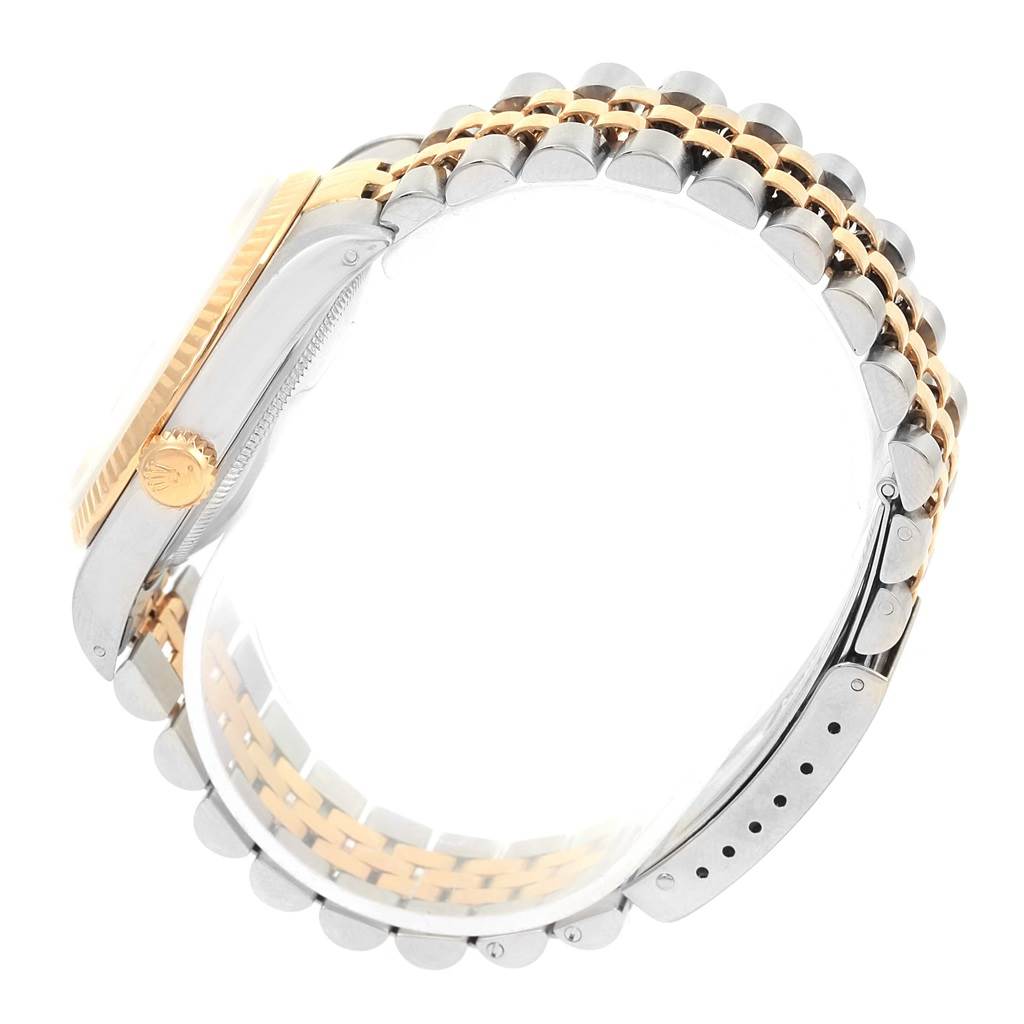 The image shows a side view of the Rolex Datejust 16233 Men's Steel and Gold (two tone) Champagne Dial 16233 Men's Steel and Gold (two tone) Champagne Dial watch, highlighting its gold bezel, winder, and two-tone bracelet.