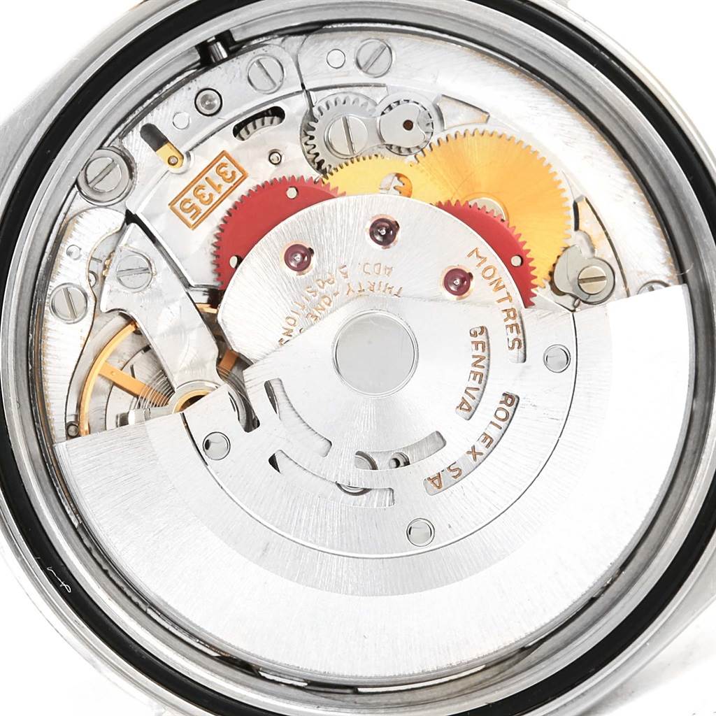 The image shows a close-up of the intricate internal movement of a Rolex Datejust 16233 Men's Steel and Gold (two tone) Champagne Dial 16233 Men's Steel and Gold (two tone) Champagne Dial watch, revealing gears and mechanical components.