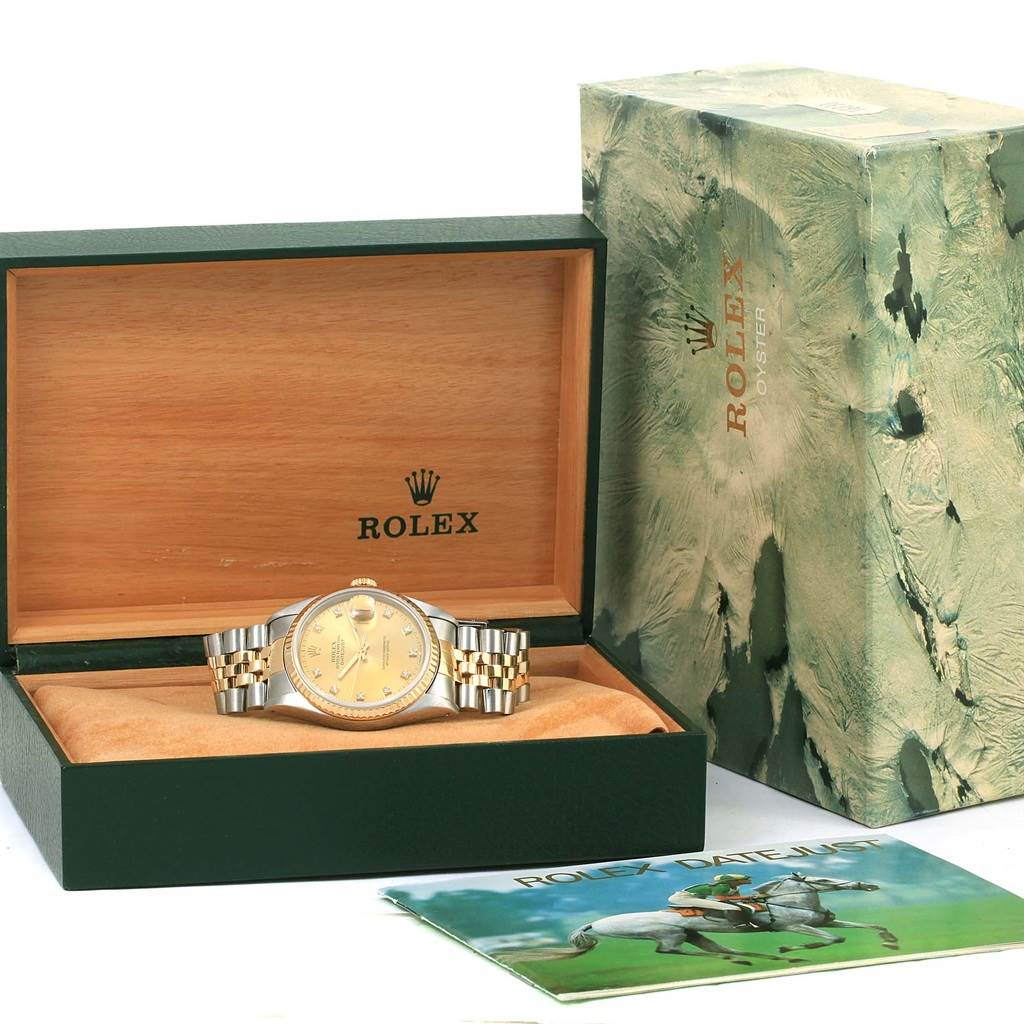 The image shows a Rolex Datejust 16233 Men's Steel and Gold (two tone) Champagne Dial 16233 Men's Steel and Gold (two tone) Champagne Dial watch inside an open presentation box, alongside its packaging and a booklet.