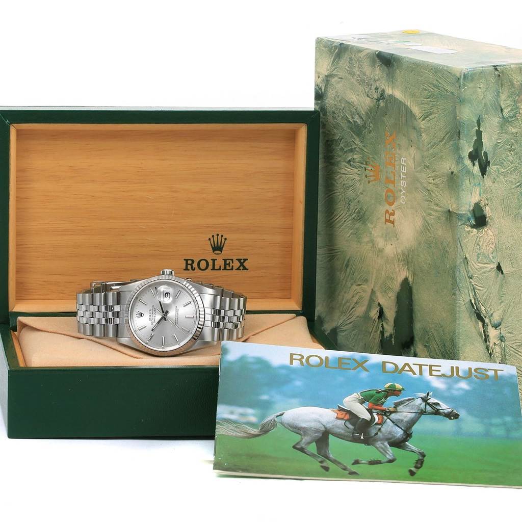 The Rolex Datejust 16234 Men
s Stainless Steel Silver Dial 16234 Men
s Stainless Steel Silver Dial watch is shown front-facing inside its open box with packaging and a booklet beside it.