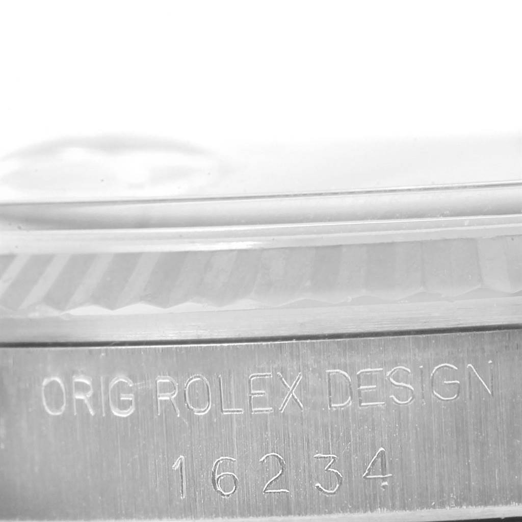 This image shows a close-up of a Rolex Datejust 16234 Men
s Stainless Steel Silver Dial 16234 Men
s Stainless Steel Silver Dial model case engraved with "ORIG ROLEX DESIGN 16234."