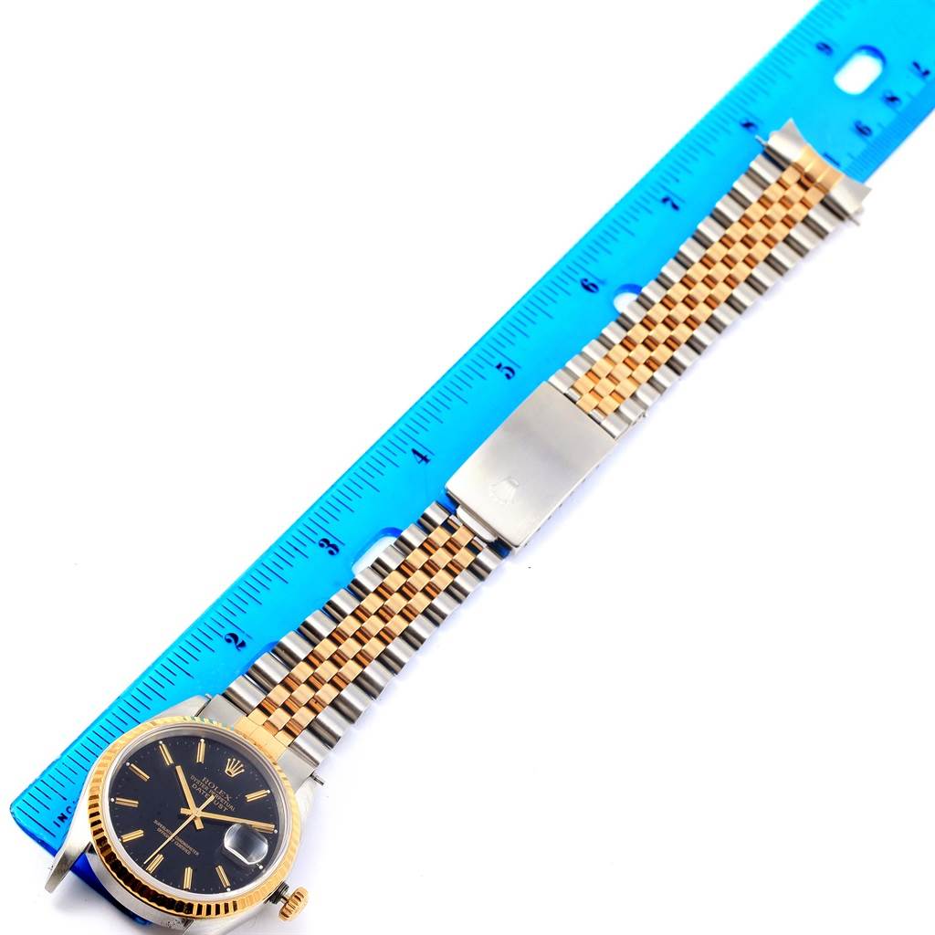 The image shows a Rolex Datejust 16233 Men
s Steel and Gold (two tone) Black Dial 16233 Men
s Steel and Gold (two tone) Black Dial watch, focusing on the face, bezel, and the full bracelet alongside a measurement ruler.