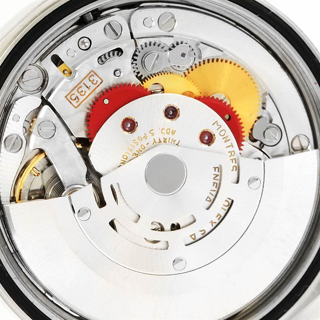 The image shows a close-up of the movement mechanism inside a Rolex Datejust 16233 Men
s Steel and Gold (two tone) Black Dial 16233 Men
s Steel and Gold (two tone) Black Dial watch, highlighting its intricate gears and components.