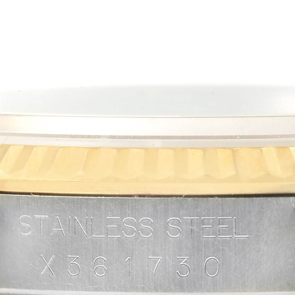 This close-up image of the Rolex Datejust 16233 Men
s Steel and Gold (two tone) Black Dial 16233 Men
s Steel and Gold (two tone) Black Dial shows the side of the watch case with engraving and part of the bezel.