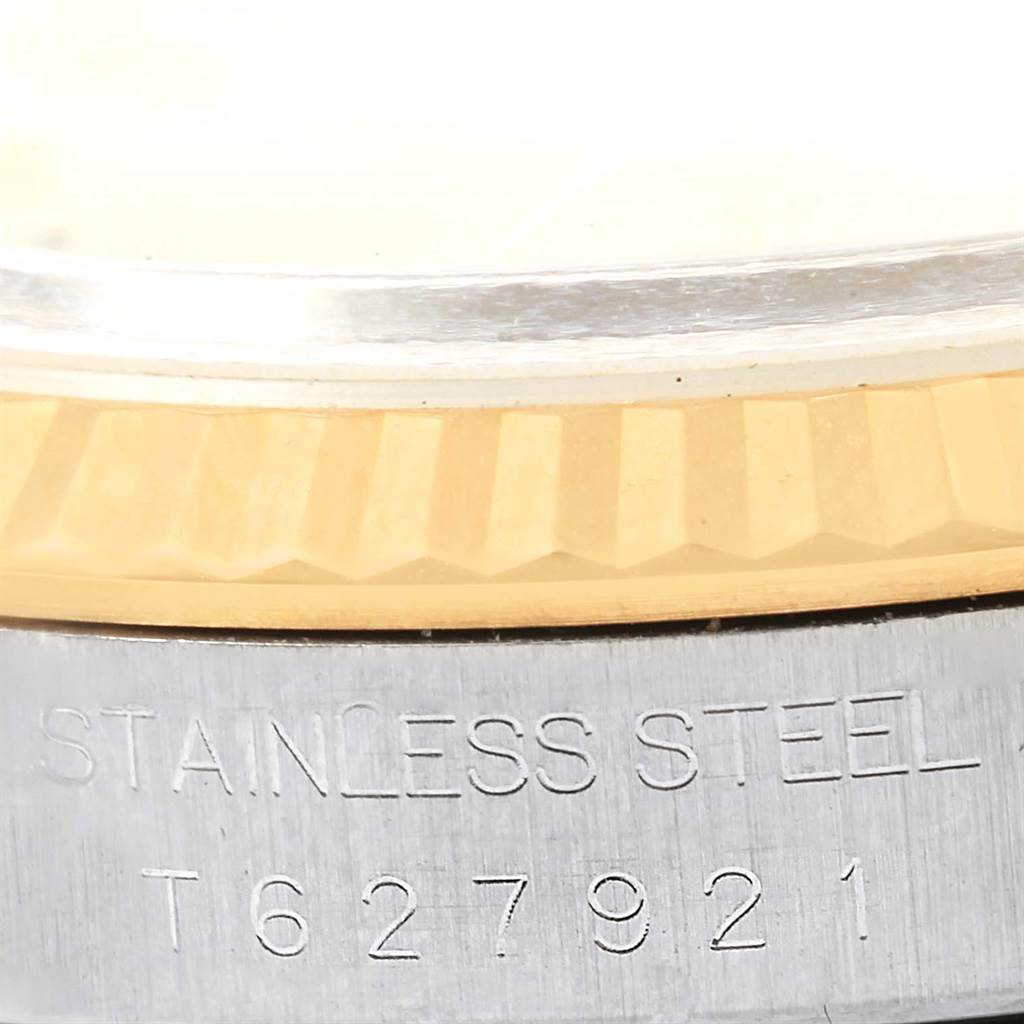 This close-up image of a Rolex Datejust 16233 Men's Steel and Gold (two tone) Champagne Dial 16233 Men's Steel and Gold (two tone) Champagne Dial watch shows the fluted bezel and part of the case back with serial number engraving.