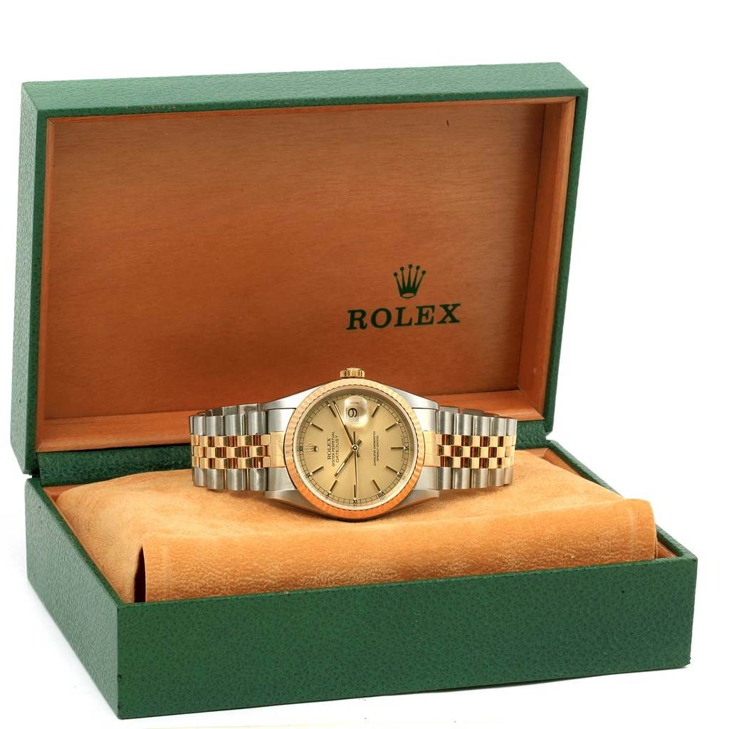 The Rolex Datejust 16233 Men's Steel and Gold (two tone) Champagne Dial 16233 Men's Steel and Gold (two tone) Champagne Dial watch is displayed head-on in its open green and beige box, showing the dial, bezel, and bracelet.