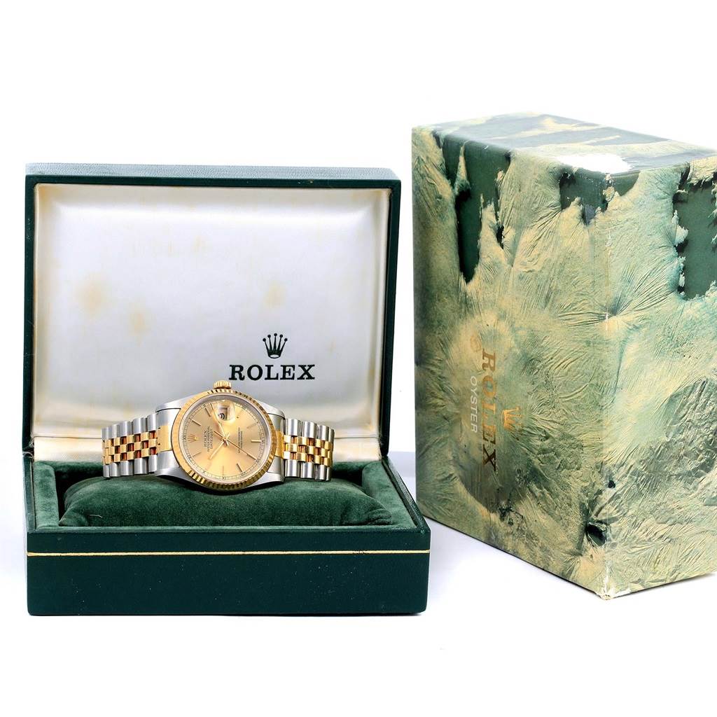 The watch is a Rolex Datejust 16233 Men's Steel and Gold (two tone) Champagne Dial 16233 Men's Steel and Gold (two tone) Champagne Dial model displayed front-facing in an open green box, with the outer box beside it.