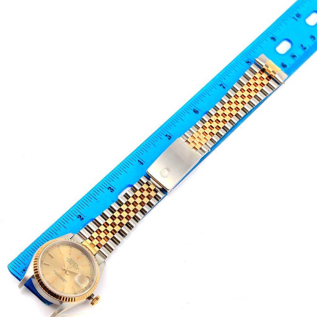 The image shows a Rolex Datejust 16233 Men's Steel and Gold (two tone) Champagne Dial 16233 Men's Steel and Gold (two tone) Champagne Dial watch laid flat with a blue ruler beside it, displaying the watch face and entire bracelet.