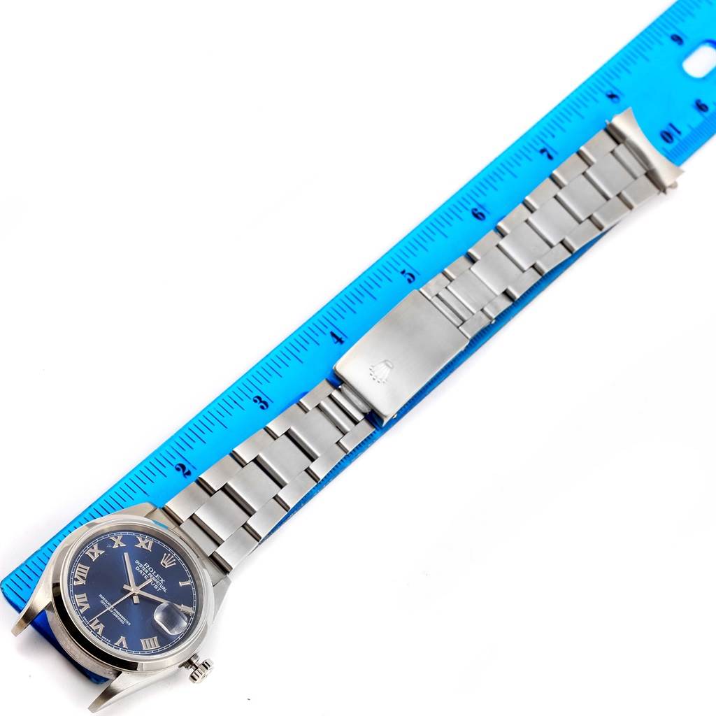 The photo shows a Rolex Datejust 16200 Men's Stainless Steel Blue Dial 16200 Men's Stainless Steel Blue Dial watch laid flat, displaying the dial, bracelet, and clasp, next to a ruler for scale.