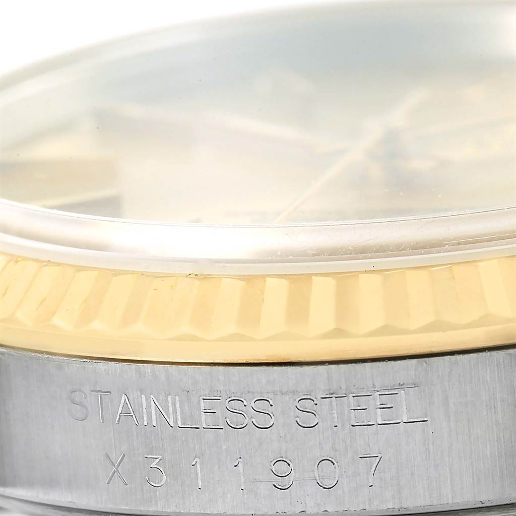 The image shows a close-up of the Rolex Datejust 16233 Men's Steel and Gold (two tone) Champagne Dial 16233 Men's Steel and Gold (two tone) Champagne Dial model's bezel and part of its case with the "STAINLESS STEEL" engraving.