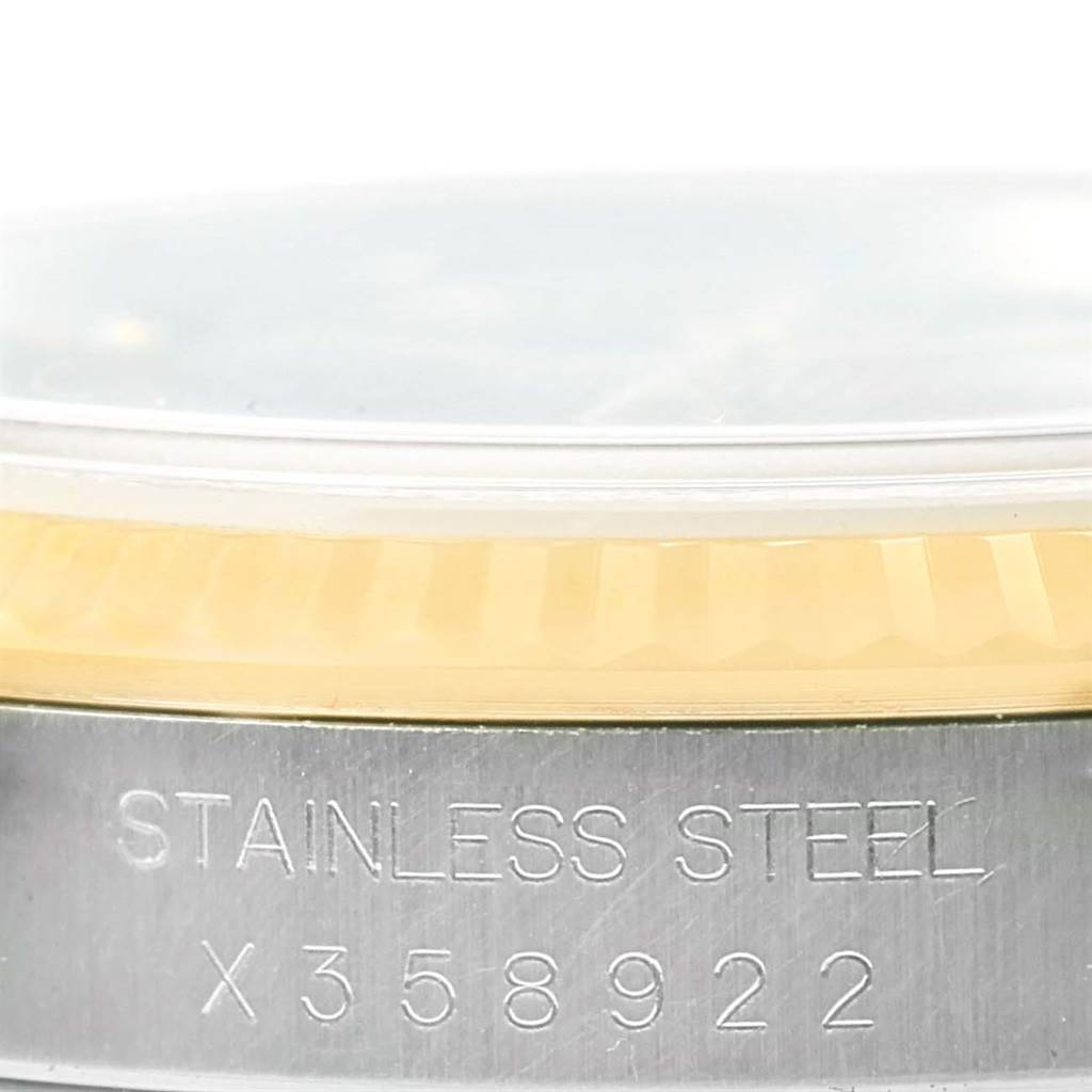 The image shows a close-up of the side of a Rolex Datejust 16233 Men's Steel and Gold (two tone) Black Dial 16233 Men's Steel and Gold (two tone) Black Dial watch, highlighting its case with a stainless steel band and serial number.