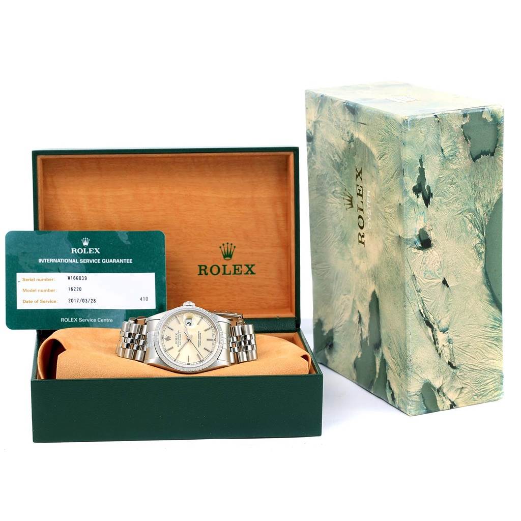 The Rolex Datejust 16220 Men's Stainless Steel Silver Dial 16220 Men's Stainless Steel Silver Dial watch is displayed in an open box with a guarantee card and outer box visible.