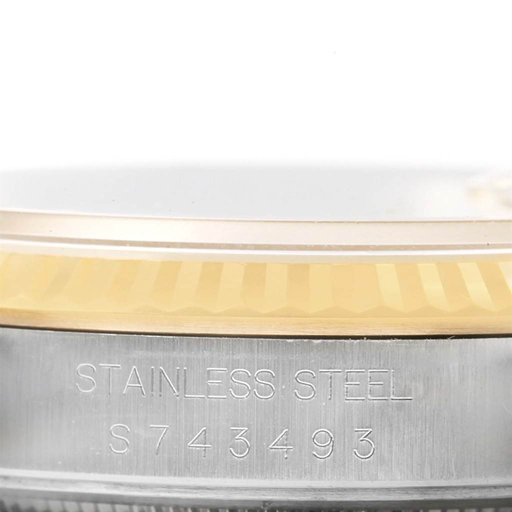 This close-up image of the Rolex Datejust 16233 Men's Steel and Gold (two tone) Champagne Dial 16233 Men's Steel and Gold (two tone) Champagne Dial model shows the edge of the bezel and part of the case back with the serial number.