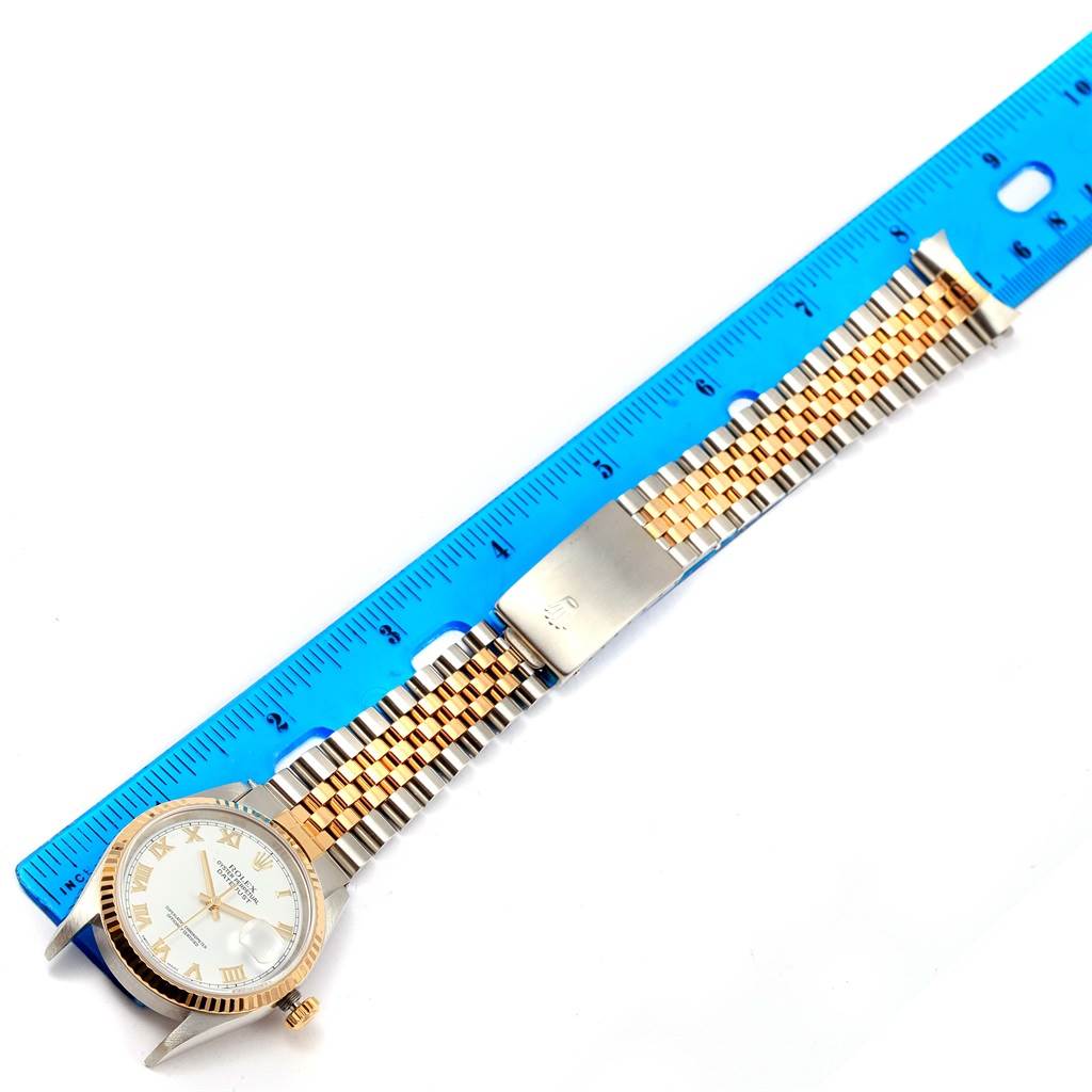 The image shows a Rolex Datejust 16233 Men's Steel and Gold (two tone) White Dial 16233 Men's Steel and Gold (two tone) White Dial watch laid flat with a blue ruler measuring its gold and silver bracelet.