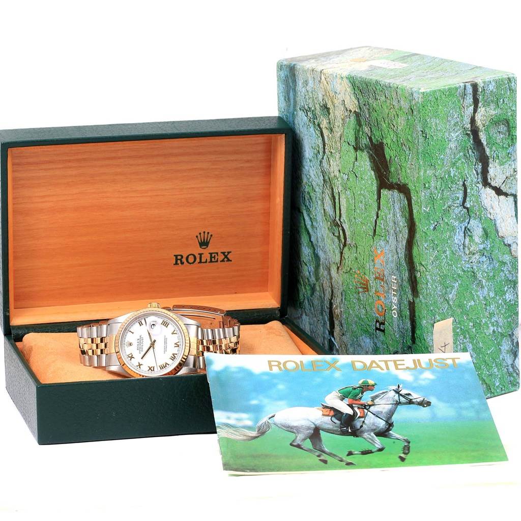 The Rolex Datejust 16233 Men's Steel and Gold (two tone) White Dial 16233 Men's Steel and Gold (two tone) White Dial watch is displayed in its open box with a booklet beside it and the outer green textured box in the background.