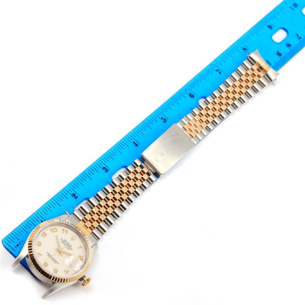 This image shows a Rolex Datejust 16233 Men's Steel and Gold (two tone) Beige Dial 16233 Men's Steel and Gold (two tone) Beige Dial watch laid flat with its bracelet fully extended and a ruler for scale.