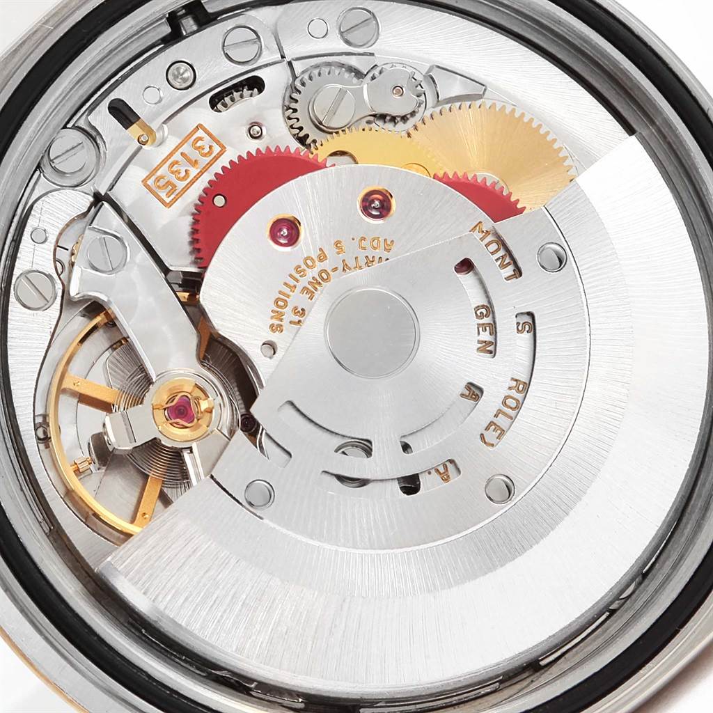 This is a close-up view of the movement of a Rolex Datejust 16233 Men's Steel and Gold (two tone) Beige Dial 16233 Men's Steel and Gold (two tone) Beige Dial watch, showing gears, rotors, and other internal components.