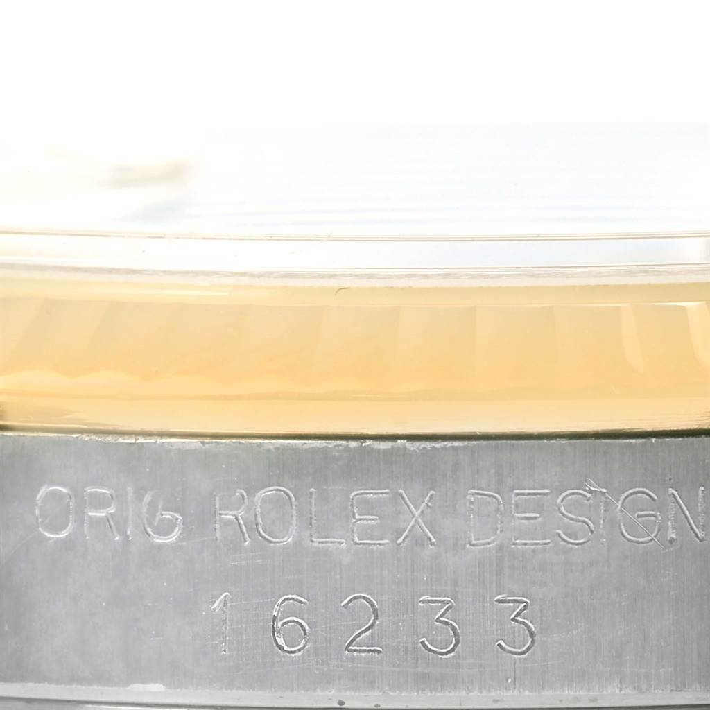 This close-up angle shows the engraved model number (16233) and part of the fluted bezel of the Rolex Datejust 16233 Men's Steel and Gold (two tone) White Dial 16233 Men's Steel and Gold (two tone) White Dial.