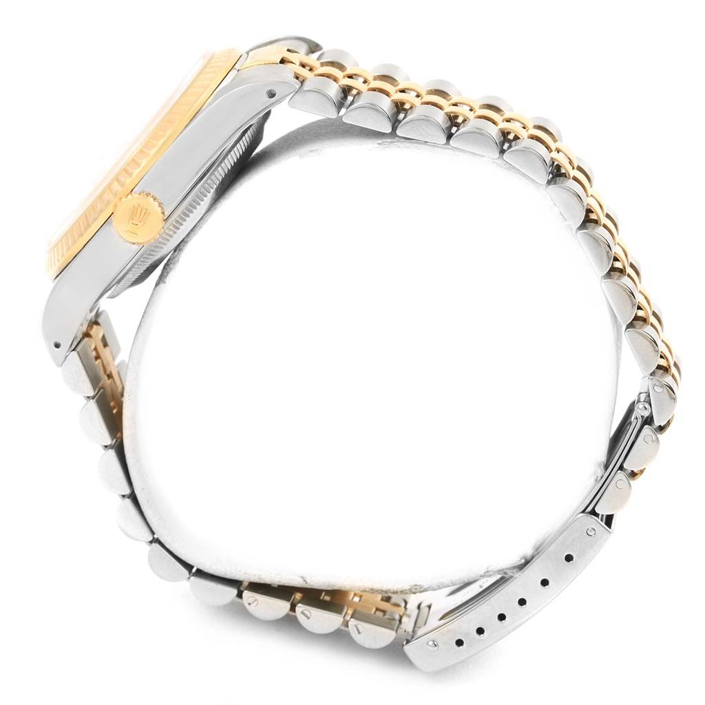 The image shows the side view of a Rolex Datejust 16233 Men's Steel and Gold (two tone) White Dial 16233 Men's Steel and Gold (two tone) White Dial watch, highlighting its bezel, crown, and two-tone bracelet.