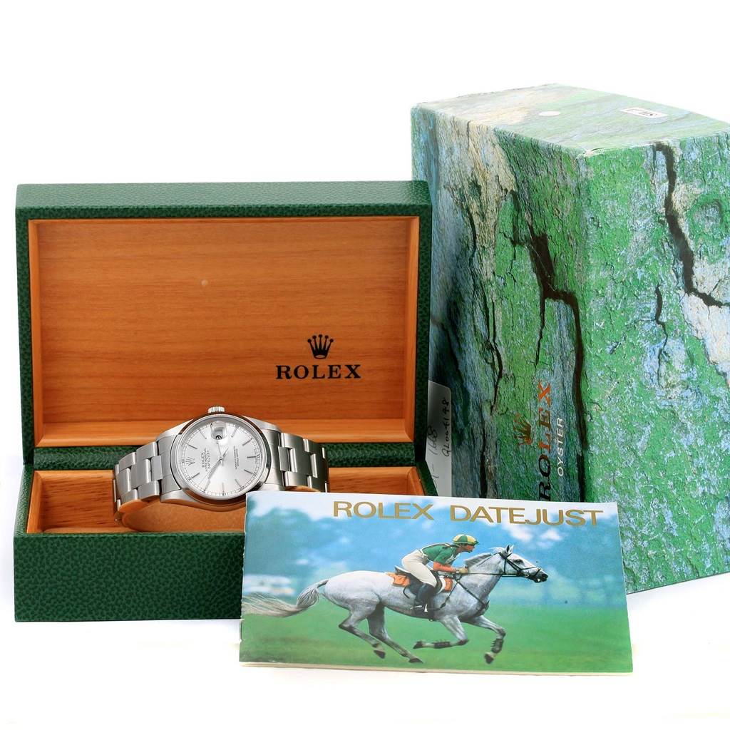 The Rolex Datejust 16200 Men's Stainless Steel Silver Dial 16200 Men's Stainless Steel Silver Dial watch is shown stored in its open wooden box, with a green outer box and a booklet beside it.