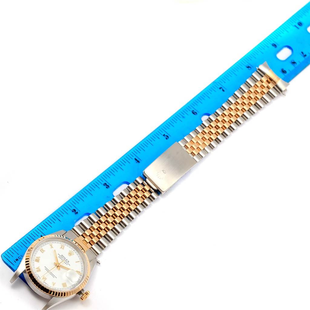 The image shows a Rolex Datejust 16233 Men's Steel and Gold (two tone) White Dial 16233 Men's Steel and Gold (two tone) White Dial watch laid flat with a blue ruler measuring the length of its two-tone metal bracelet.