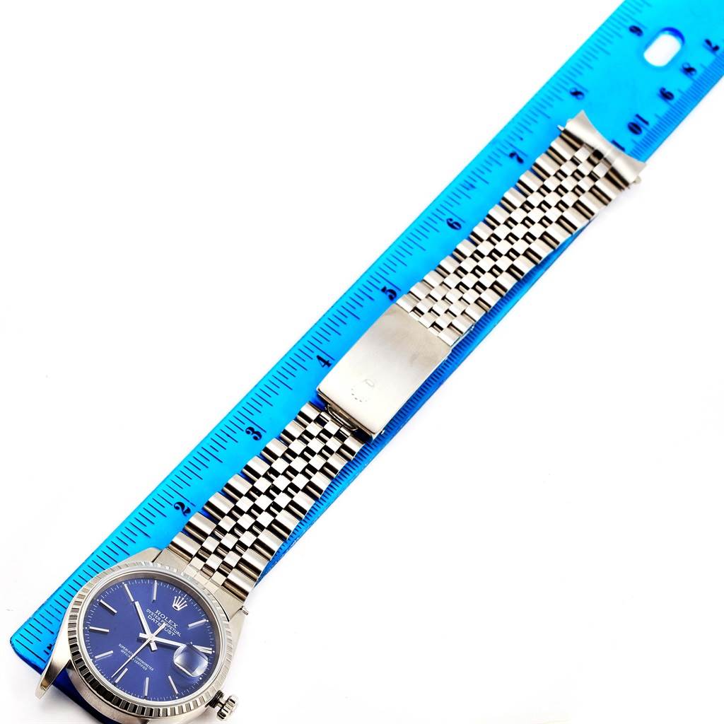 The image shows a Rolex Datejust 16220 Men's Stainless Steel Blue Dial 16220 Men's Stainless Steel Blue Dial watch laid flat next to a ruler, displaying the face, bracelet, and clasp.