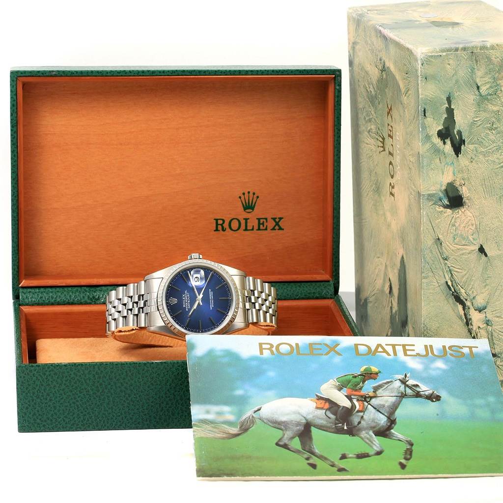 The image shows a Rolex Datejust 16220 Men's Stainless Steel Blue Dial 16220 Men's Stainless Steel Blue Dial watch in an open green and wood box, with its booklet and outer box also visible.