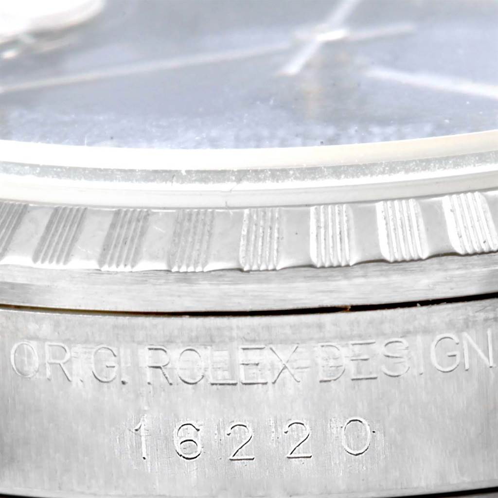This close-up angle of the Rolex Datejust 16220 Men's Stainless Steel Blue Dial 16220 Men's Stainless Steel Blue Dial watch focuses on the bezel and model number engraved on the case.
