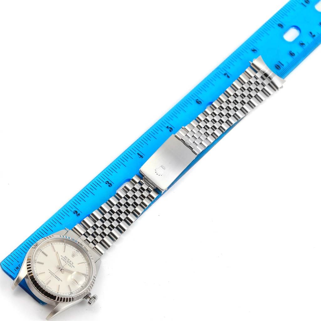 The image shows a top-down view of a Rolex Datejust 16234 Men's Stainless Steel Silver Dial 16234 Men's Stainless Steel Silver Dial watch, displaying the face, bezel, and metal bracelet next to a blue ruler.