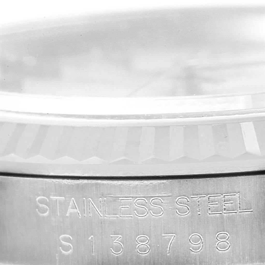 This close-up image of a Rolex Datejust 16234 Men's Stainless Steel Silver Dial 16234 Men's Stainless Steel Silver Dial watch shows the fluted bezel and part of the stainless steel casing with an engraved serial number.