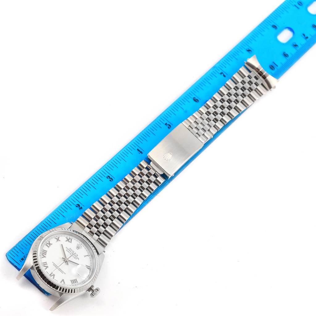 The image shows a full view of a Rolex Datejust 16234 Men's Stainless Steel White Dial 16234 Men's Stainless Steel White Dial watch, including the face, bezel, and metal bracelet with a ruler for scale.