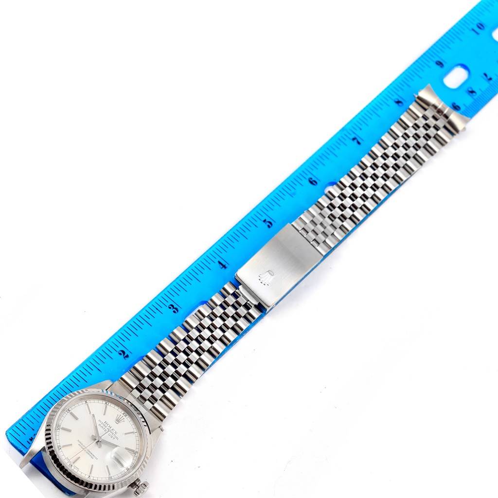 The image shows a Rolex Datejust 16234 Men's Stainless Steel Silver Dial 16234 Men's Stainless Steel Silver Dial watch laid flat with a metal bracelet next to a blue ruler for measurement.