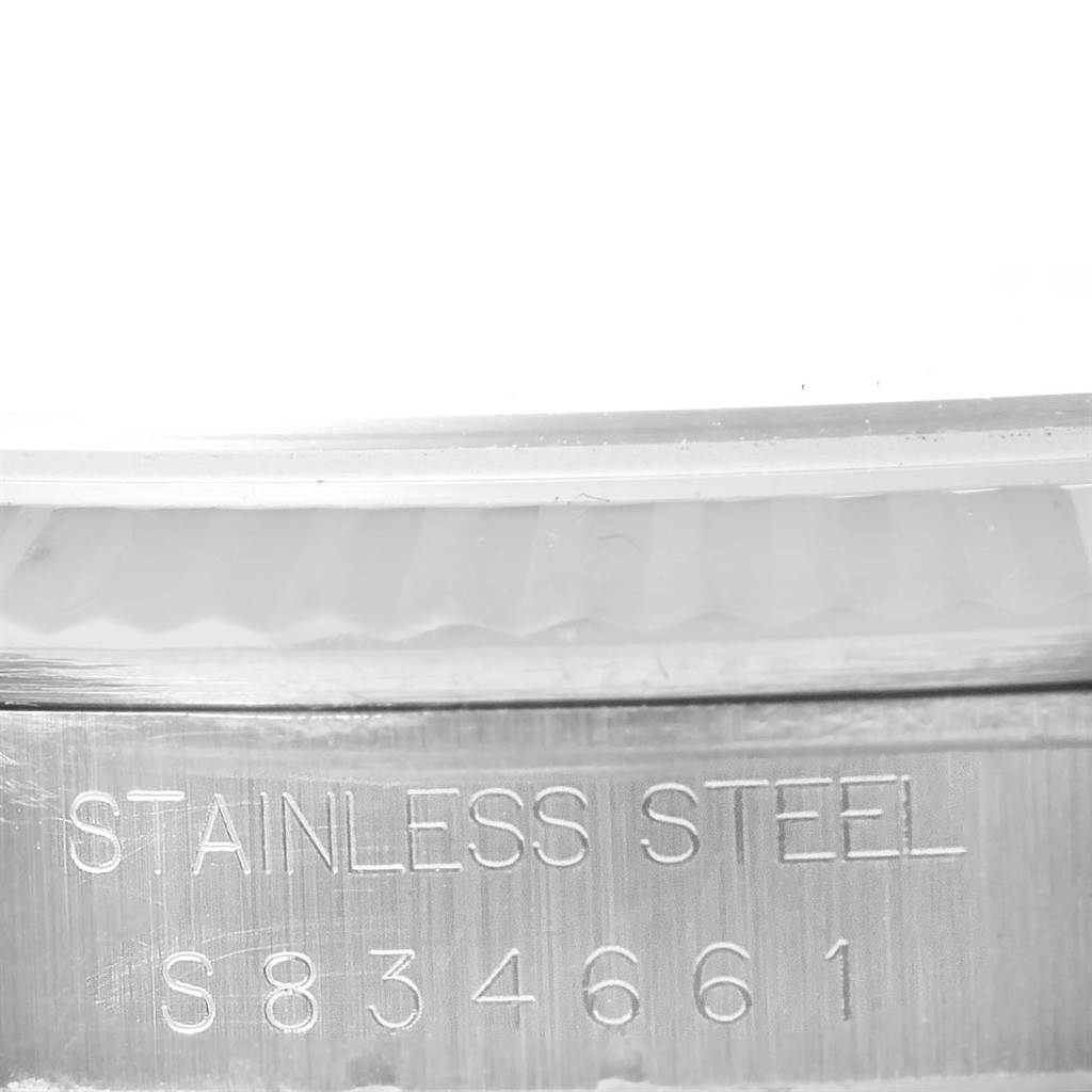 The image shows a close-up angle of a Rolex Datejust 16234 Men's Stainless Steel Silver Dial 16234 Men's Stainless Steel Silver Dial's stainless steel case with an engraved serial number.