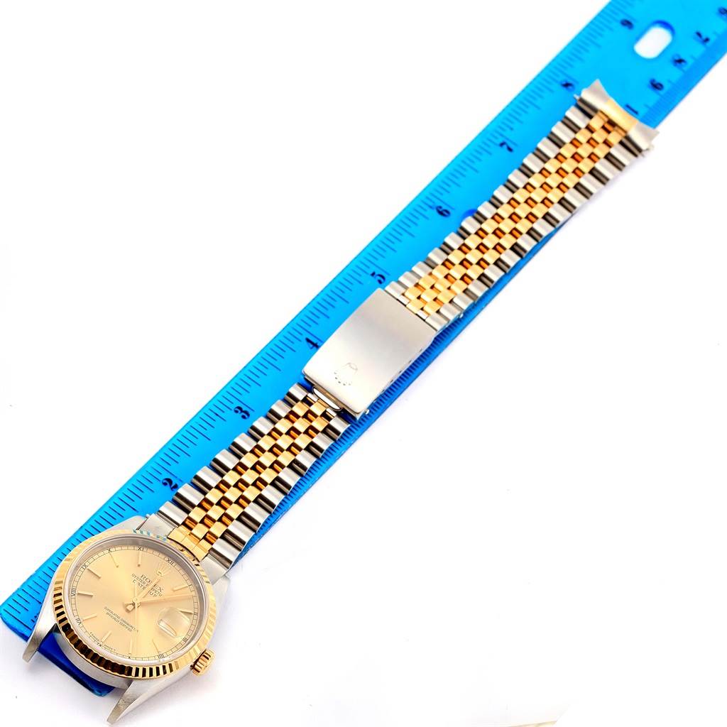 The Rolex Datejust 16233 Steel and Gold (two tone) Champagne Dial 16233 Steel and Gold (two tone) Champagne Dial watch is shown laid flat with a focus on the face, bezel, and bracelet, alongside a blue ruler.