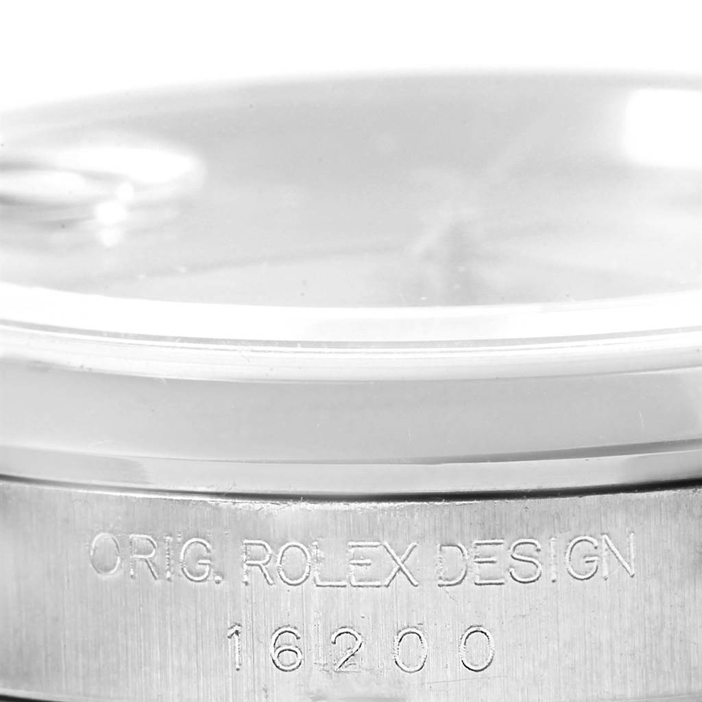 The image shows a close-up of the Rolex Datejust 16200 Men's Stainless Steel Silver Dial 16200 Men's Stainless Steel Silver Dial watch, highlighting the engraved model number and "Orig. Rolex Design" on the case.