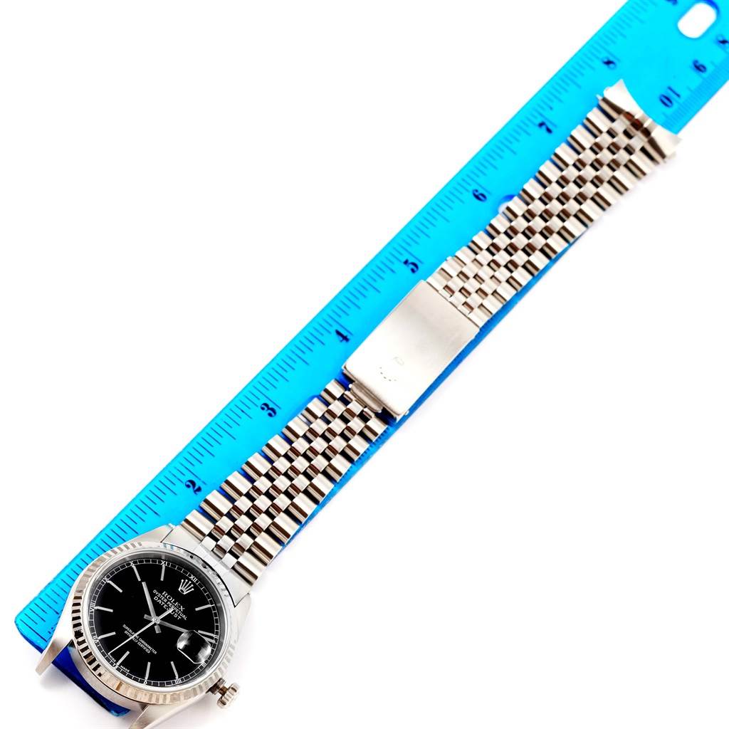 The image shows a top-down view of a Rolex Datejust 16234 Men's Stainless Steel Black Dial 16234 Men's Stainless Steel Black Dial watch face and full bracelet, placed alongside a blue ruler for size reference.